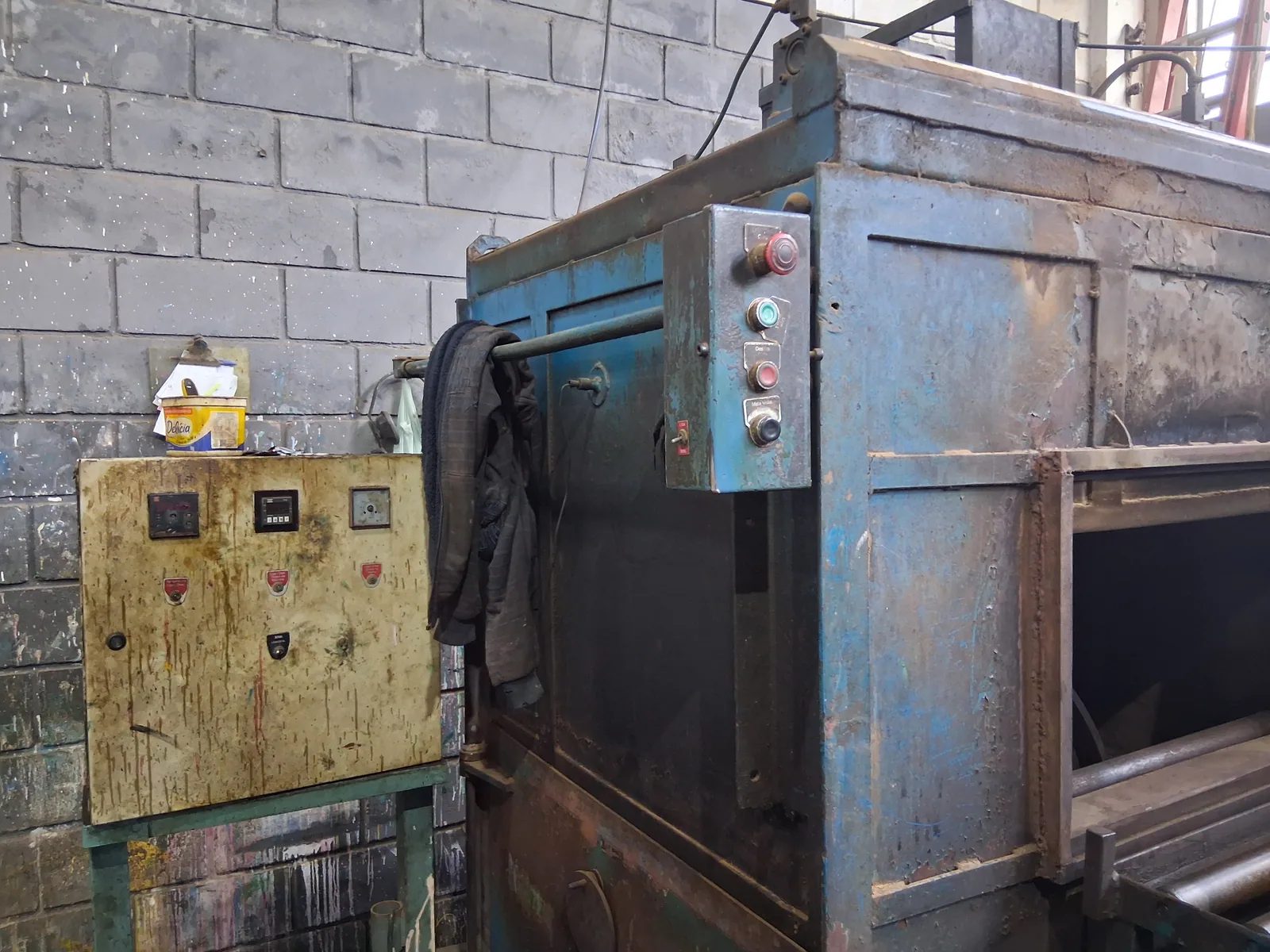Máquina modeladora de plástico com painel de comando antigo, enferrujado e defeituoso